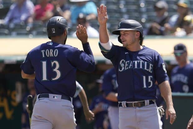 Two Seattle Mariners players celebrate with a high five on the field during a baseball game, 2K Desktop Wallpaper