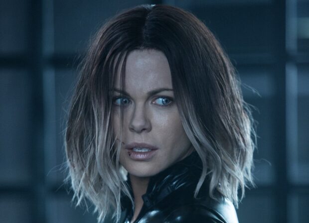 Selene is shown with a serious expression and blue eyes in a dark setting, HD Desktop Wallpaper