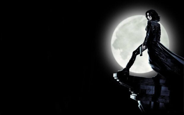 Selene stands on a ledge holding a gun with a bright full moon behind her, HD Desktop Wallpaper