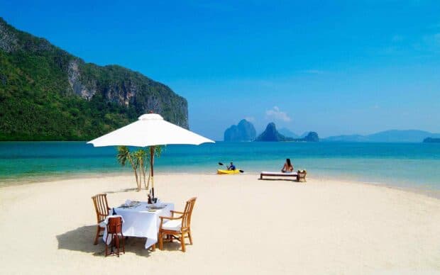 A peaceful beach with a dining setup and distant islands in the clear blue Palawan waters, 2K Desktop Wallpaper