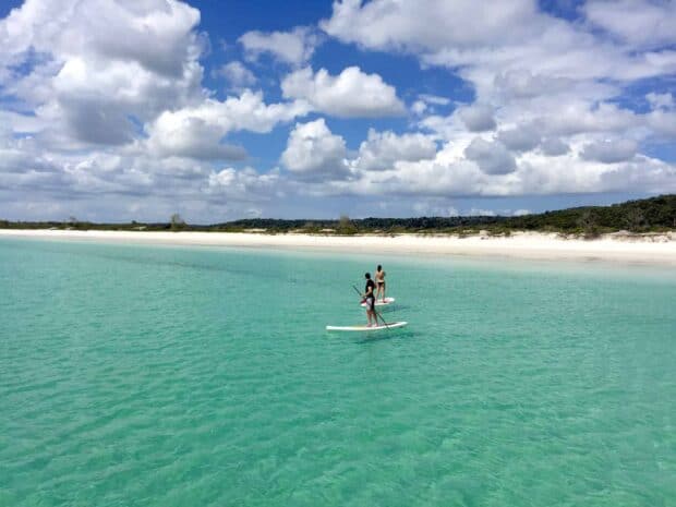 Two people paddleboarding on clear turquoise water near Fraser Island, HD Desktop Wallpaper