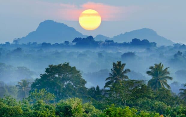 The Vietnam Wallpapers show a peaceful sunrise above the misty mountains and lush greenery, 2K Desktop Wallpaper