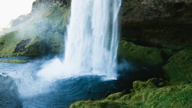 A stunning waterfall surrounded by lush green moss and rocks in Uganda, 4K Desktop Wallpaper