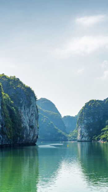 The clear green water reflects towering limestone cliffs in this Vietnam Wallpapers scene, HD Phone Wallpaper