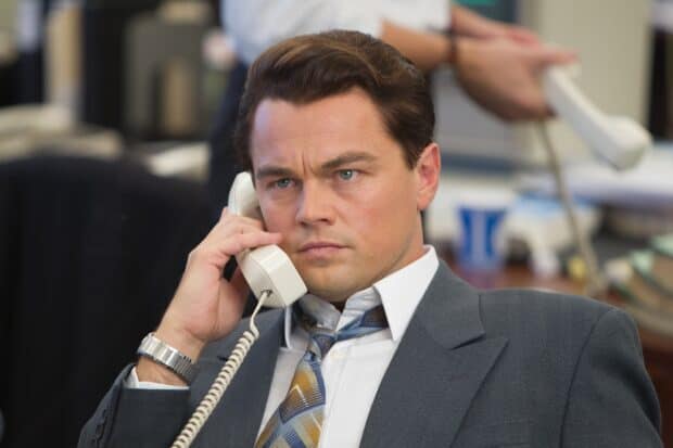A man in a suit is making a phone call in a busy office setting, 2K Desktop Wallpaper