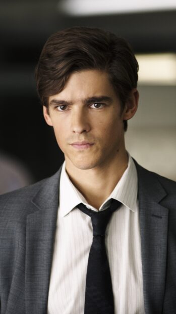 A serious young man is wearing a gray suit and black tie in a scene from the Titans Tv Series, 4K Phone Wallpaper