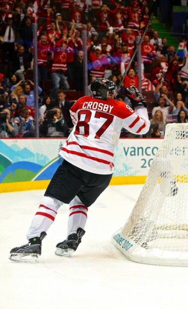 Sidney Crosby celebrates a goal during a hockey game with fans cheering in the background, HD Phone Wallpaper