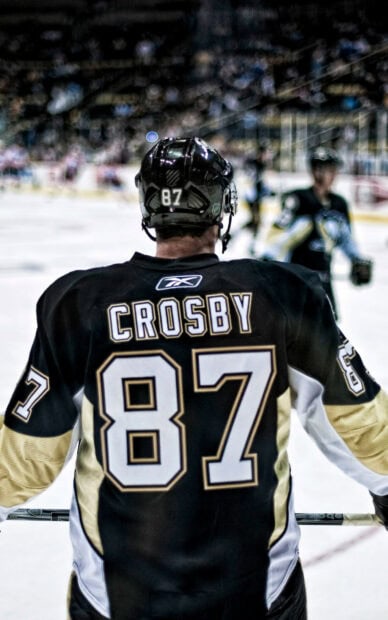 Sidney Crosby is standing on the ice during a hockey game, HD Phone Wallpaper
