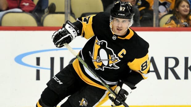 Sidney Crosby is playing ice hockey in a black and yellow Pittsburgh Penguins jersey, HD Desktop Wallpaper