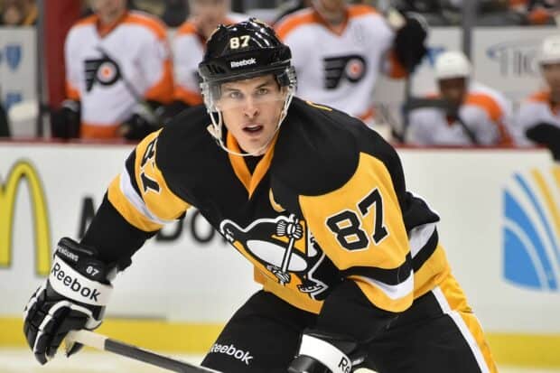 Sidney Crosby is shown focused during a hockey game wearing black and yellow uniform, HD Desktop Wallpaper