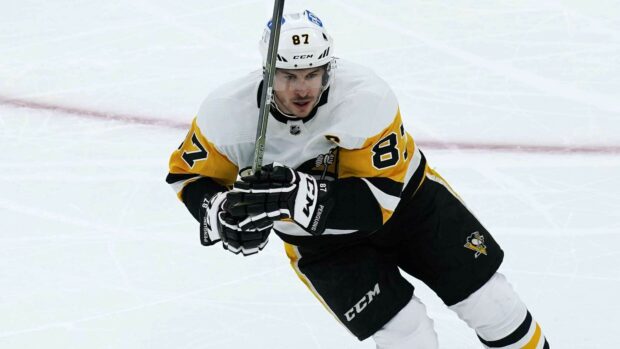 Sidney Crosby skates during an intense hockey game wearing a white and yellow uniform, HD Desktop Wallpaper