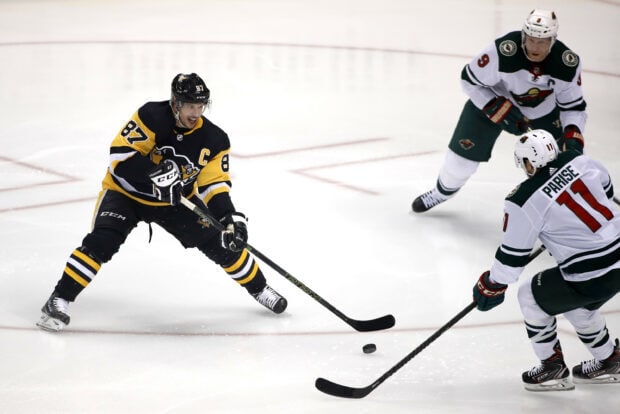 Sidney Crosby in action on ice during a hockey game with opponents, 2K Desktop Wallpaper