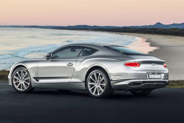 A silver Bentley Continental GT is parked near the seaside during sunset, 2K Desktop Wallpaper