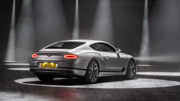 A silver Bentley Continental GT shines under dramatic stage lights, 4K Desktop Wallpaper