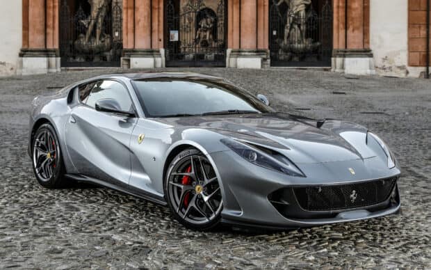 A silver Ferrari 812 Gts parked on a cobblestone road in front of a historic building, HD Desktop Wallpaper