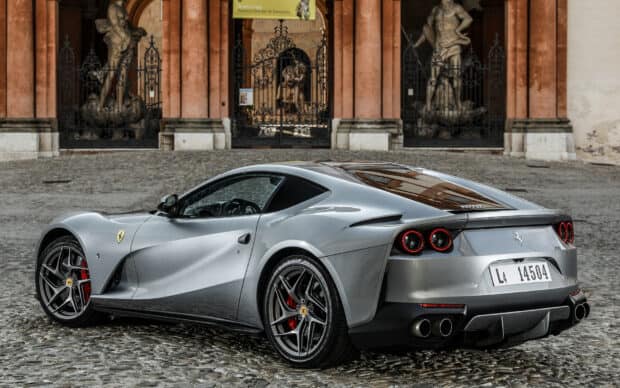 A silver Ferrari 812 Gts is parked on cobblestone in front of an ornate historic building, HD Desktop Wallpaper