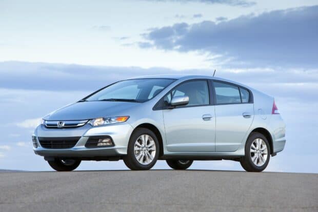 A silver Honda Insight is parked on a deserted road under a cloudy sky, showcasing its aerodynamic design, HD Desktop Wallpaper