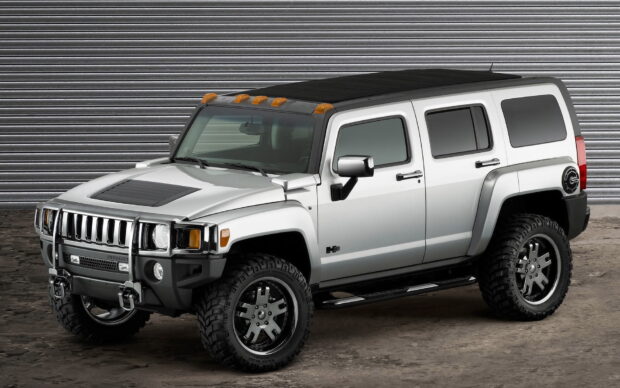 A silver Hummer H3 is parked in front of a metal shutter wall, HD Desktop Wallpaper