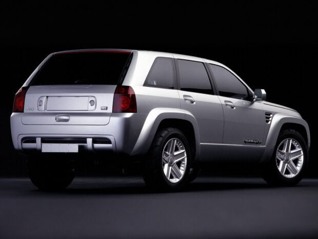 A silver Jeep Commander SUV is displayed from the rear side in a dark studio, HD Desktop Wallpaper
