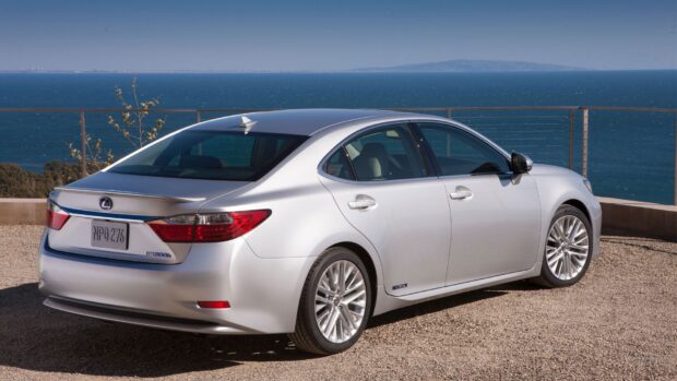 A silver Lexus ES is parked on a gravel lot near the ocean with a clear blue sky, HD Desktop Wallpaper