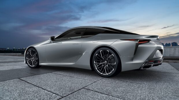 This image shows a silver Lexus LC sports car parked on a tiled surface with a city skyline at dusk, HD Desktop Wallpaper