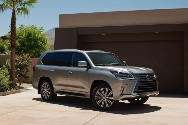 Lexus LX is shown parked outside a contemporary home on a sunny day, 2K Desktop Wallpaper