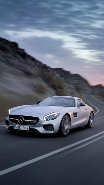 A silver Mercedes Benz AMG GT drives along a winding mountain road under a cloudy sky, HD Phone Wallpaper