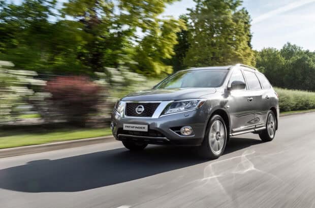 A Nissan Pathfinder drives swiftly along a road surrounded by greenery, 2K Desktop Wallpaper