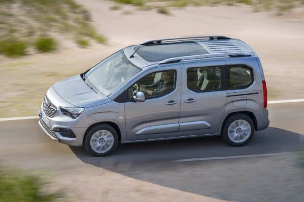 A silver Opel Combo with a driver is seen moving on a paved road, HD Desktop Wallpaper