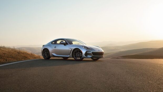 A silver Subaru Brz is parked on an open road with hills in the background at sunset, 2K Desktop Wallpaper