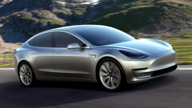A silver Tesla Model 3 is driving fast on a road near rocky hills under clear skies, HD Desktop Wallpaper