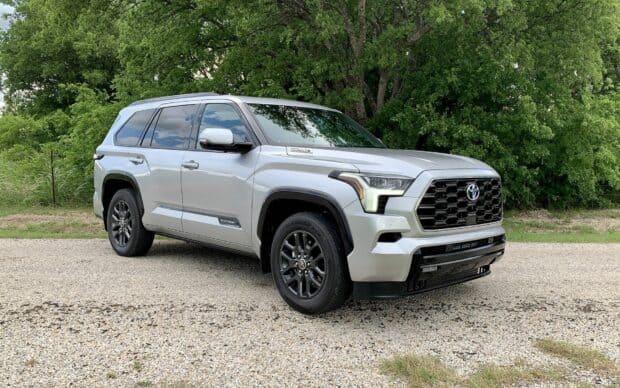 A silver Toyota Sequoia is parked on a gravel road with green trees in the background, HD Desktop Wallpaper