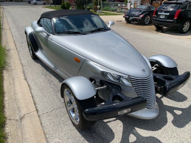 A silver Plymouth Prowler car is parked on a sunny street with reflections on its body, HD Desktop Wallpaper