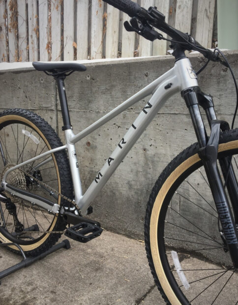 A silver mountain bike with Marin Bikes logos parked near a concrete wall, HD Desktop Wallpaper