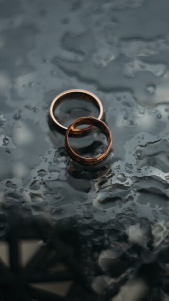 Two wedding rings resting on a wet reflective surface, HD Phone Wallpaper