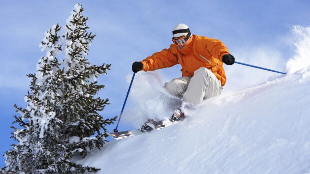 A skier is wearing an orange jacket and skiing down a snow covered mountain, HD Desktop Wallpaper