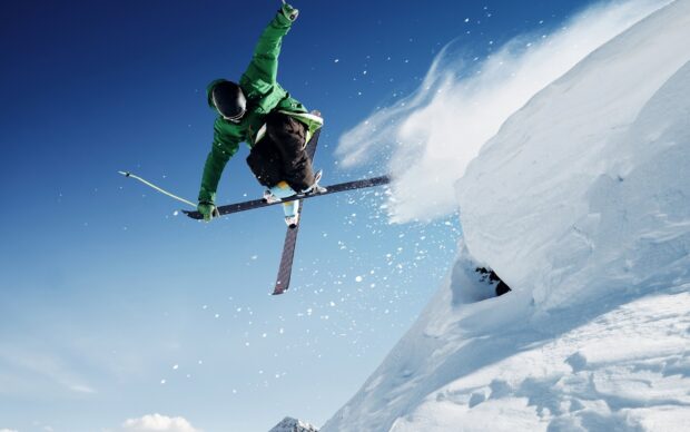 A skier performs an impressive jump over fresh snow in clear weather skiing wallpapers, 2K Desktop Wallpaper