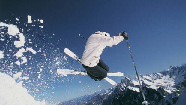 A skier performs a high jump in the snow with skiing wallpapers in a clear blue sky, HD Desktop Wallpaper
