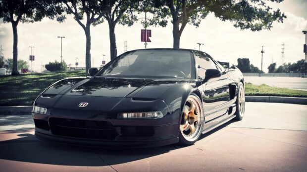 A sleek black Honda NSX is parked under trees in an outdoor lot on a sunny day, HD Desktop Wallpaper