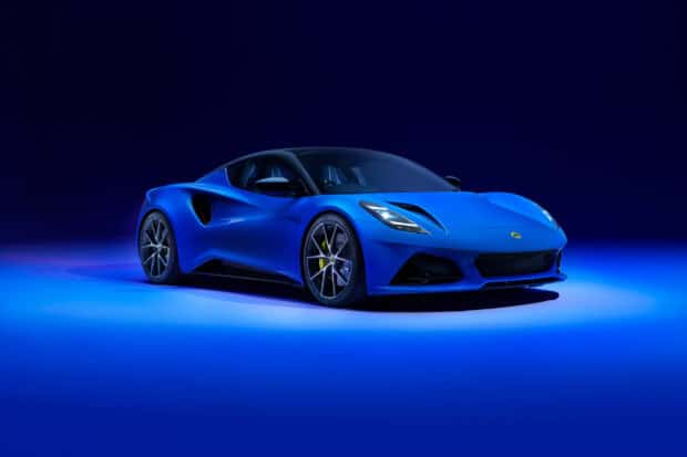 A blue Lotus Emira stands illuminated against a dark blue background showcasing its sleek lines, 2K Desktop Wallpaper