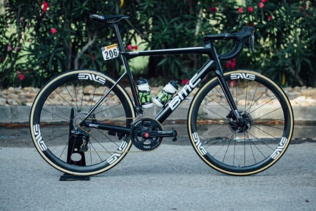A sleek Bmc Bikes model stands on a road with greenery in the background, HD Desktop Wallpaper