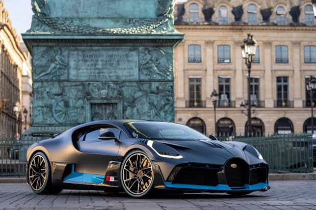 A Bugatti Divo is parked in front of a historic monument in the city, 2K Desktop Wallpaper
