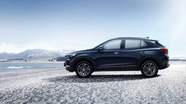 A black Buick Encore drives on a snowy shore with mountains in the background, HD Desktop Wallpaper