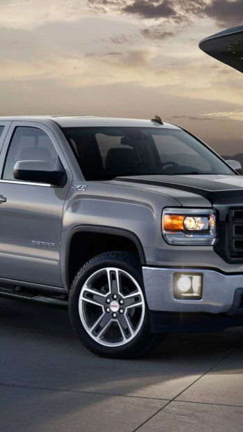 A sleek gray GMC Sierra pickup truck is parked outdoors at sunset, showcasing its front and side design, HD Phone Wallpaper