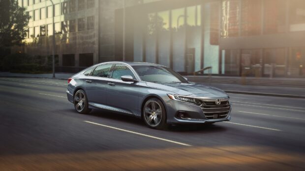 A silver Honda Accord is driving smoothly along an urban road with modern buildings in the background, HD Desktop Wallpaper