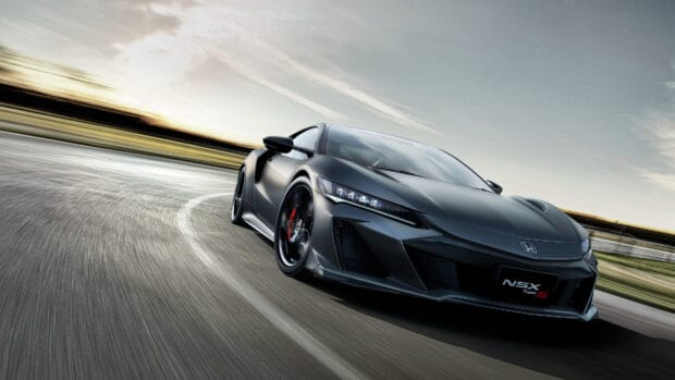 A sleek Honda NSX is shown taking a sharp turn at high speed on a race track with motion blur, 4K Desktop Wallpaper