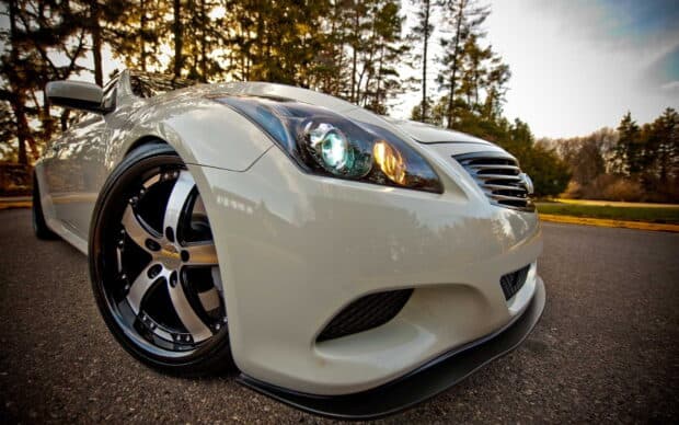 A sleek white Infiniti G37 is parked on the road with trees in the background, HD Desktop Wallpaper