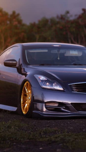 A sleek Infiniti G37 with custom golden rims is parked on a rural road, HD Phone Wallpaper