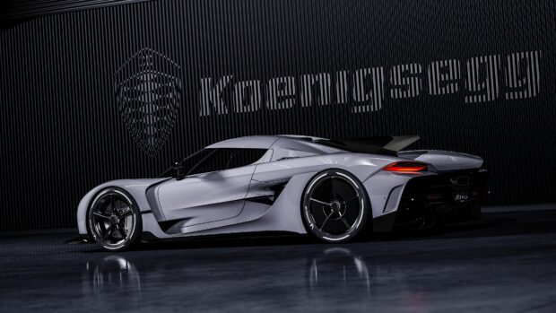 A sleek Koenigsegg sports car is parked indoors with the brand's logo in the background, 4K Desktop Wallpaper