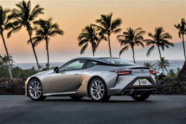 A silver Lexus LC is parked near palm trees with the ocean in the background during sunset, 2K Desktop Wallpaper